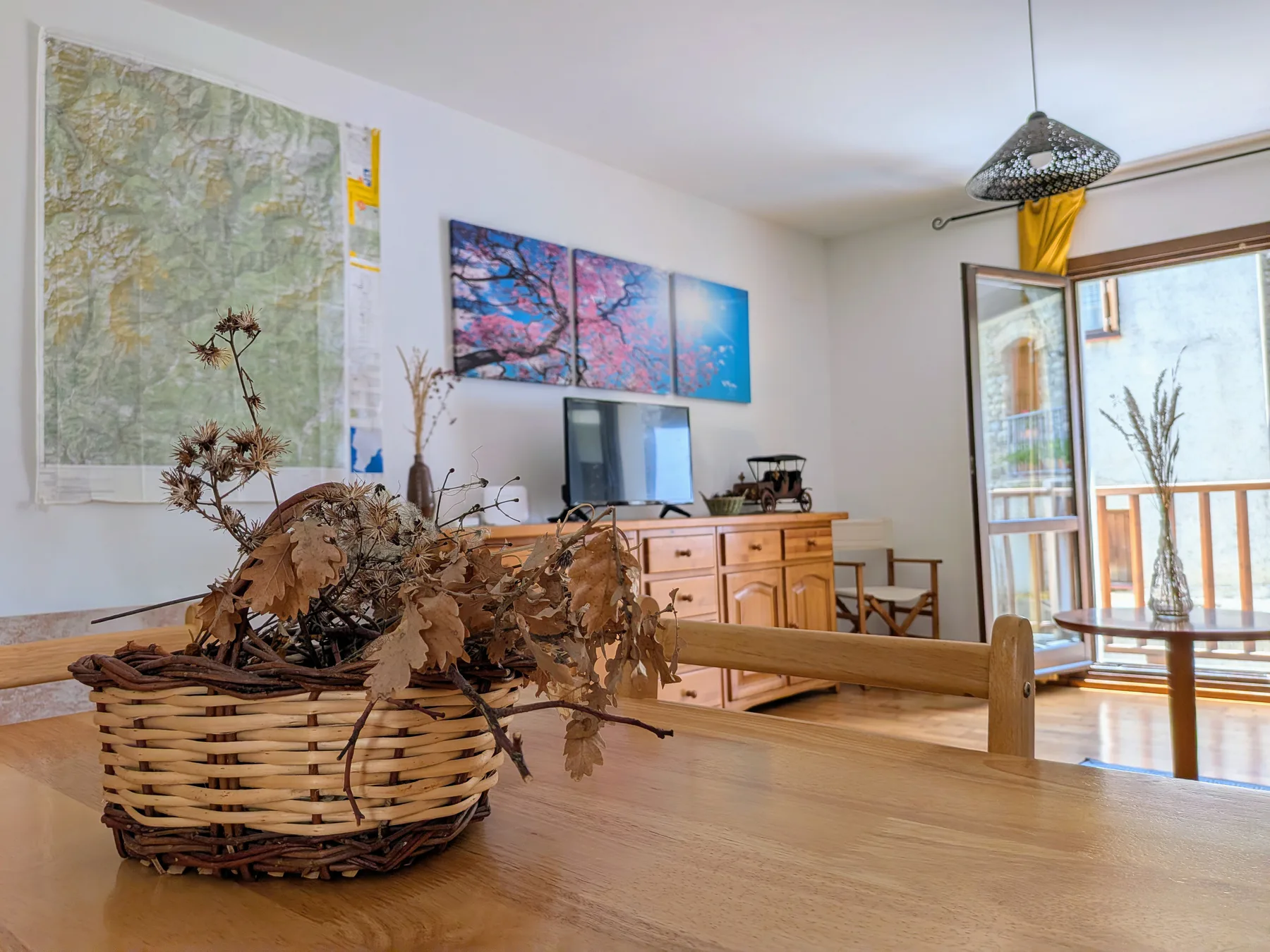 Comedor del apartamento con una cesta sobre la mesa y salón al fondo